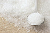 close image of sugar granules and a spoon